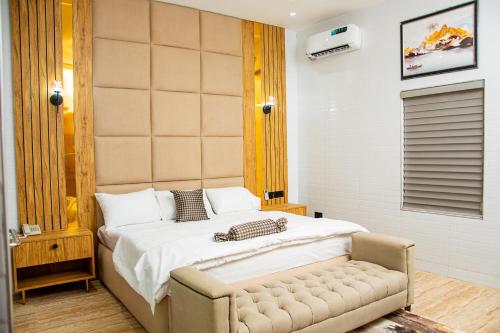a bedroom with a bed and a bench in it at NIFEWAT APARTMENT,2 bedroom apartment NICE SUITE with pool, gym,Netflix, WiFi and sitting out area in Abuja