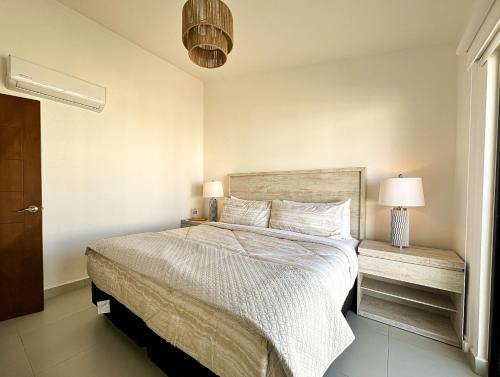 a bedroom with a bed with white sheets and two lamps at Viñedos del Mar in Ensenada