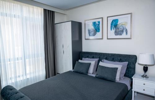 a bedroom with a bed and a window at ADIRAMA Apartments Elegant Apartments Walk to the Beach in Obzor