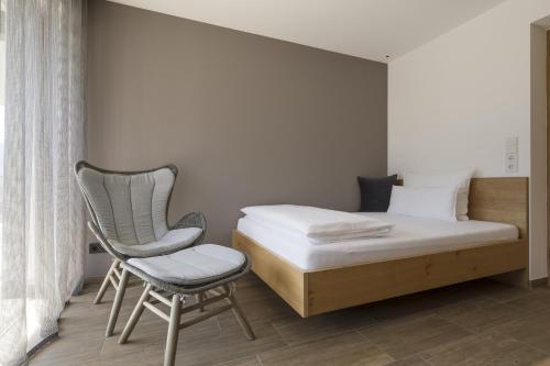 een slaapkamer met een bed en een stoel bij Residence Sonja - Suite Castanea in Rablà