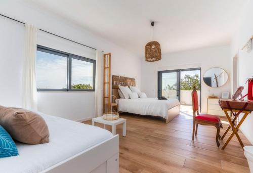 a bedroom with two beds and a desk and a table at Villa "A Vida é Linda Santa Luzia" in Santa Luzia