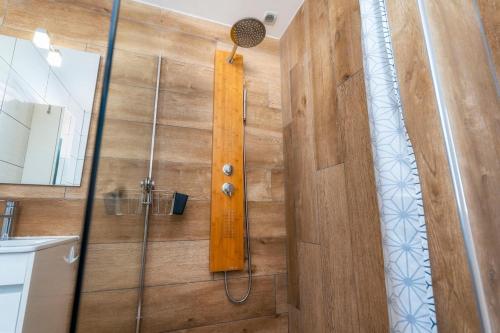 a shower in a bathroom with a wooden wall at Villa "A Vida é Linda Santa Luzia" in Santa Luzia