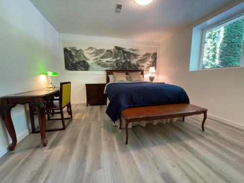 1 dormitorio con cama, mesa y escritorio en The Rhodo Place, en Coquitlam