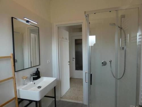 a white bathroom with a sink and a shower at Casa Cocò - Appartamento al mare in Lido di Ostia