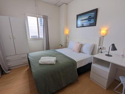 een kleine slaapkamer met een bed en een bureau bij Studio 18 Wright Lodge in Adelaide