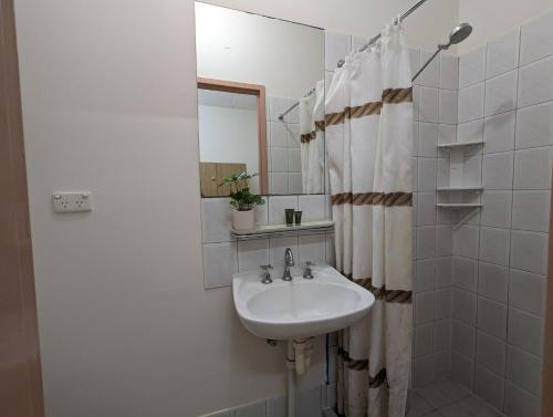 uma casa de banho branca com um lavatório e um espelho em Studio 19 Wright Lodge em Adelaide