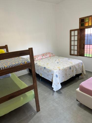 a bedroom with two bunk beds and a window at Casa com piscina em boraceia a 400 metros da praia in Boracéia
