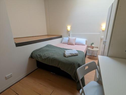 アデレードにあるStudio 20 Wright Lodgeのベッドと椅子付きの小さな部屋です。