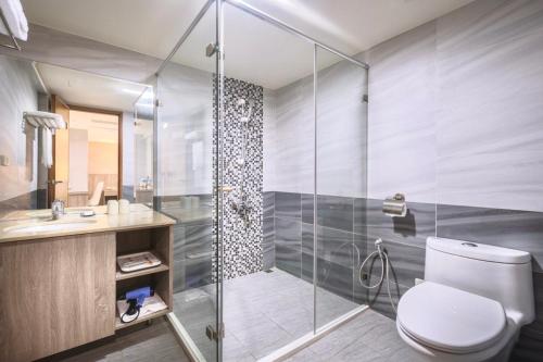 台中市にあるMei Hotelのトイレとガラスのシャワー付きのバスルーム