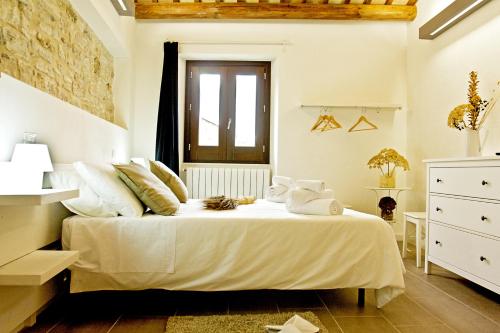 a bedroom with a bed with white sheets and a window at Residence San Martino in Erice