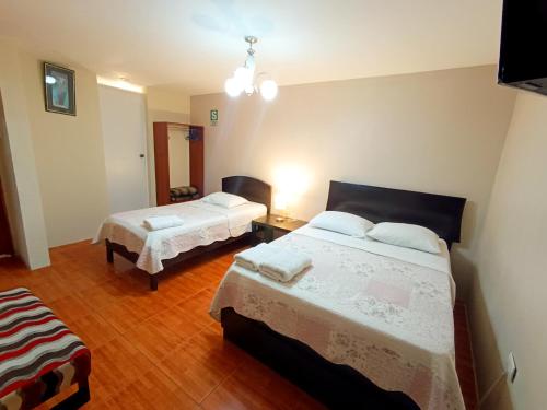 a bedroom with two beds in a room at Hotel la encantada in Cajamarca