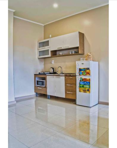 a kitchen with a white refrigerator in a room at City Views Spacious Mezzanine Apartments in Willemstad