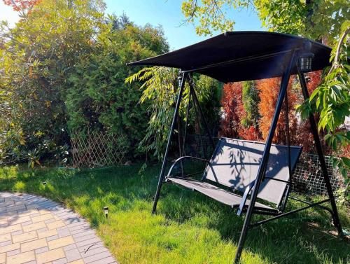 a swing with a black canopy in the grass at All-ways Home in Burnaby