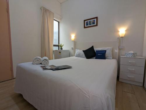 ein Schlafzimmer mit einem weißen Bett und einem Laptop darauf in der Unterkunft Studio 24 Wright Lodge in Adelaide
