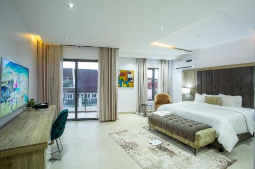 伊巴丹DE MANCHY HOTELS & SUITES的一间带大床和电视的卧室