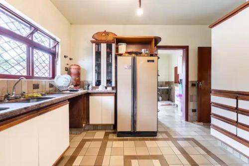a kitchen with a refrigerator in the middle of a room at Suítes encantadoras in Sao Paulo