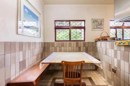 a room with a table and a wooden chair at Suítes encantadoras in Sao Paulo