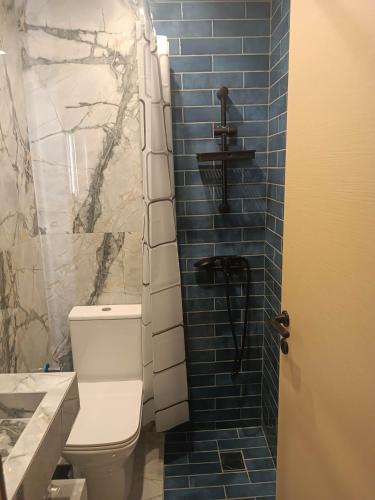 a bathroom with a toilet and a blue tile wall at Grecos STAY SKIATHOS in Skiathos Town