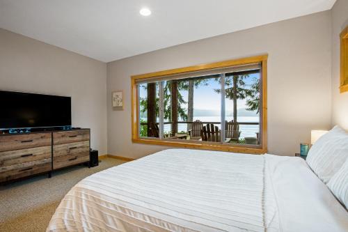 Un dormitorio con una cama y una ventana grande en Woodstone Cabin, en Hoodsport