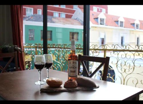 a table with a bottle of wine and two glasses at City Views Spacious Mezzanine Apartments in Willemstad