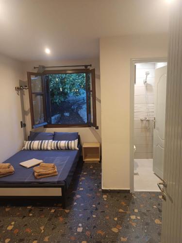 a small room with a bed and a shower at Grecos STAY SKIATHOS in Skiathos Town