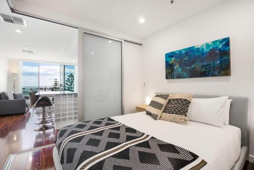 a bedroom with a bed and a large window at Coast on Colley Luxury 1BR Glenelg in Glenelg