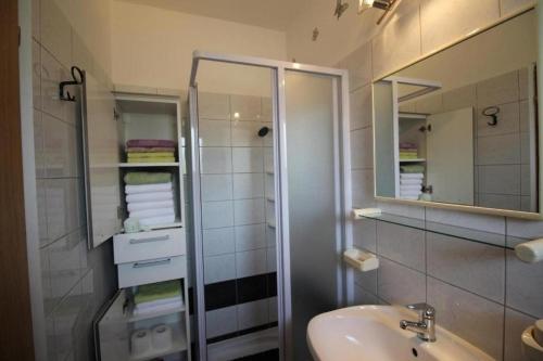 y baño con lavabo, ducha y espejo. en Apartments with a parking space Punat, Krk - 21295, en Punat