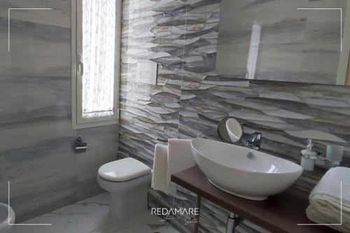 a bathroom with a white sink and a toilet at REDAMARE SUITE in Lago Patria