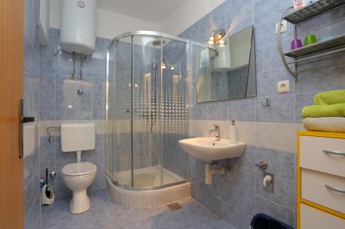 La salle de bains est pourvue d'une douche, de toilettes et d'un lavabo. dans l'établissement Apartments by the sea Kastel Kambelovac, Kastela - 20605, à Kaštela