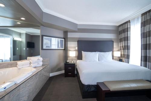 a hotel room with a bed and a bath tub at Sandman Signature Mississauga Hotel in Mississauga