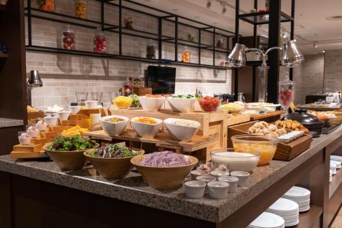 a buffet with bowls of food on a table at Premier Hotel - CABIN PRESIDENT - Hakodate in Hakodate