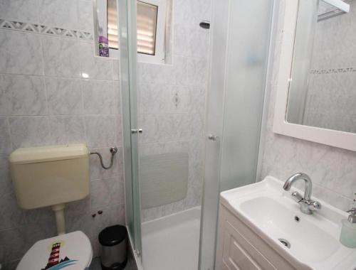 e bagno con doccia, servizi igienici e lavandino. di Apartments by the sea Punat, Krk - 21299 a Punat