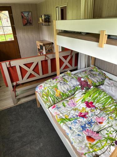 a bedroom with a bunk bed with a floral comforter at Chatka pod lesom in Banská Štiavnica
