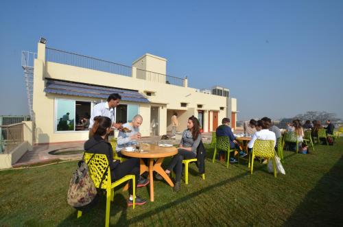a group of people sitting around a table on a lawn at Hotel Banaras Haveli in Varanasi