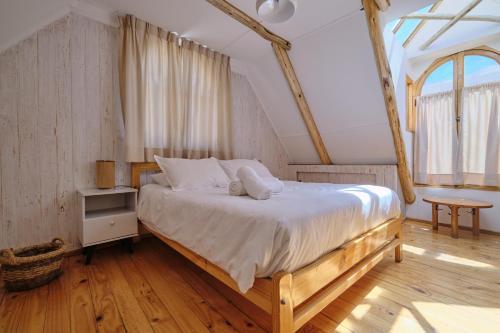 a bedroom with a large bed with a wooden floor at Hotel El Tesoro de Elqui in Pisco Elqui