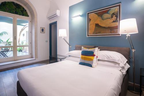 a bedroom with a bed and a painting on the wall at Palazzo Gilistro in Siracusa