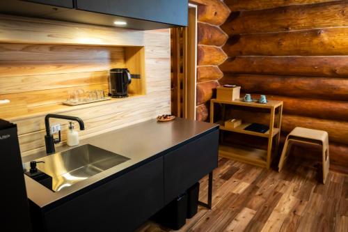 uma cozinha com um lavatório e uma parede de madeira em Hacho no Yu em Nikko
