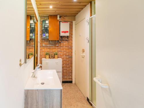 baño con lavabo y pared de ladrillo en Lovely chalet in Arendonk with terrace en Arendonk