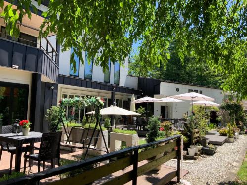 a patio with tables and umbrellas in front of a building at Kakureyado Fujikawaguchiko in Fujikawaguchiko