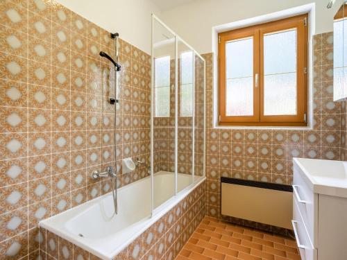 a bathroom with a tub and a sink at Holiday home in the ski area in Kötschach-Mauthen in Laas