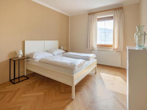 a white bedroom with a bed and a window at Holiday home in the ski area in Kötschach-Mauthen in Laas