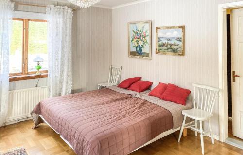 a bedroom with a large bed with red pillows at 3 Bedroom Awesome Home In Nybofjll 