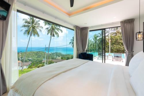a bedroom with a bed and a large window at Villa Coco in Lamai