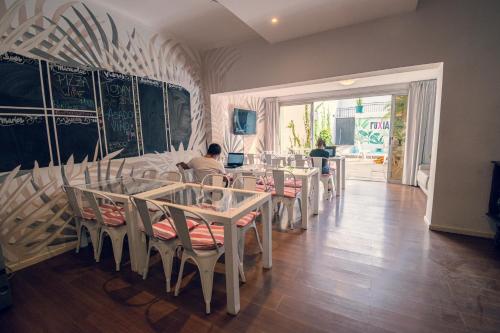 uma sala de jantar com mesas e pessoas sentadas a eles em Fuxia Jungle Hostel em Mendoza