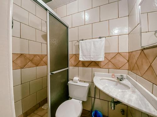 a bathroom with a toilet and a sink at Garden 437 Suítes in Florianópolis