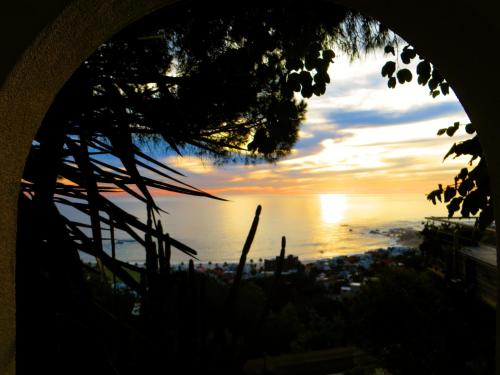 a view of the ocean at sunset through a window at Boutique@10 in Cape Town