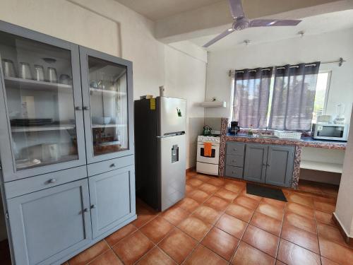 a kitchen with a white refrigerator and a counter at 1 BR APT with AC , TV , wi-fi near DT and beach in Zihuatanejo