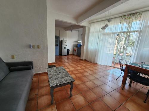a living room with a couch and a table at 1 BR APT with AC , TV , wi-fi near DT and beach in Zihuatanejo