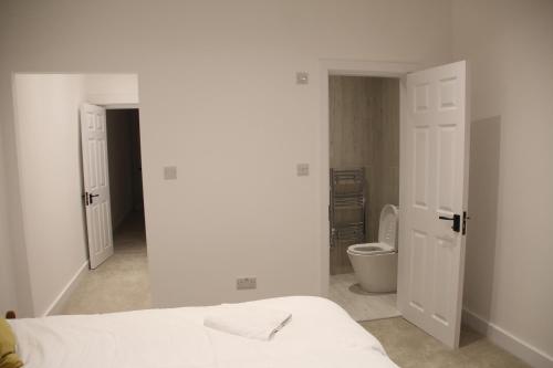 a white bedroom with a bed and a toilet at Comfortable Stone Bay window Private bathroom Ensuite Double Bedroom in Edgware