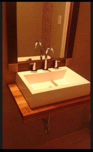 lavabo con 2 grifos y espejo en Departamento PLAYA GRANDE en Mar del Plata